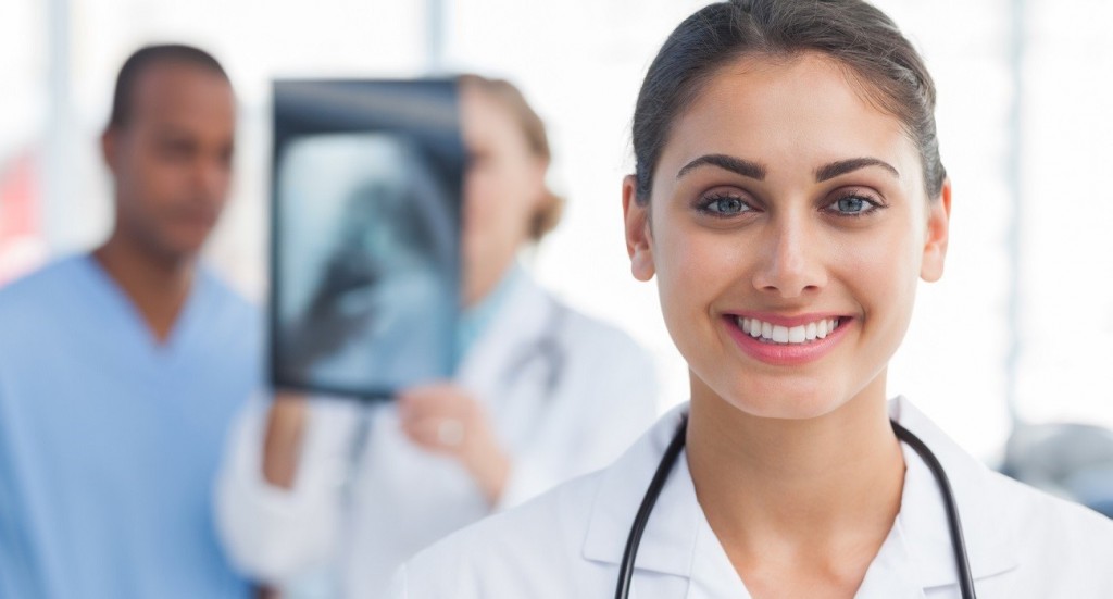 Smiling doctor standing in front of medical team analysing an x-ray